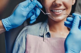 woman smiles during oral exam dental cleaning dentist in Charleston North Carolina